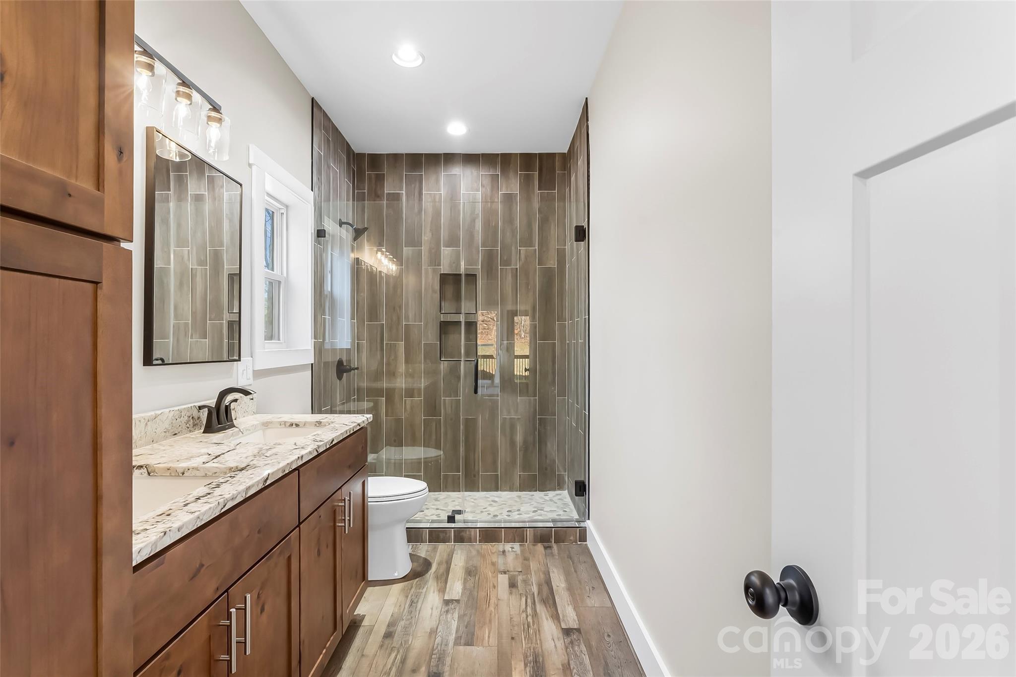 189 Clinchfield Gap Road Marion, NC 28752 - Photo 26 of 42 a bathroom with a granite countertop sink a mirror and shower