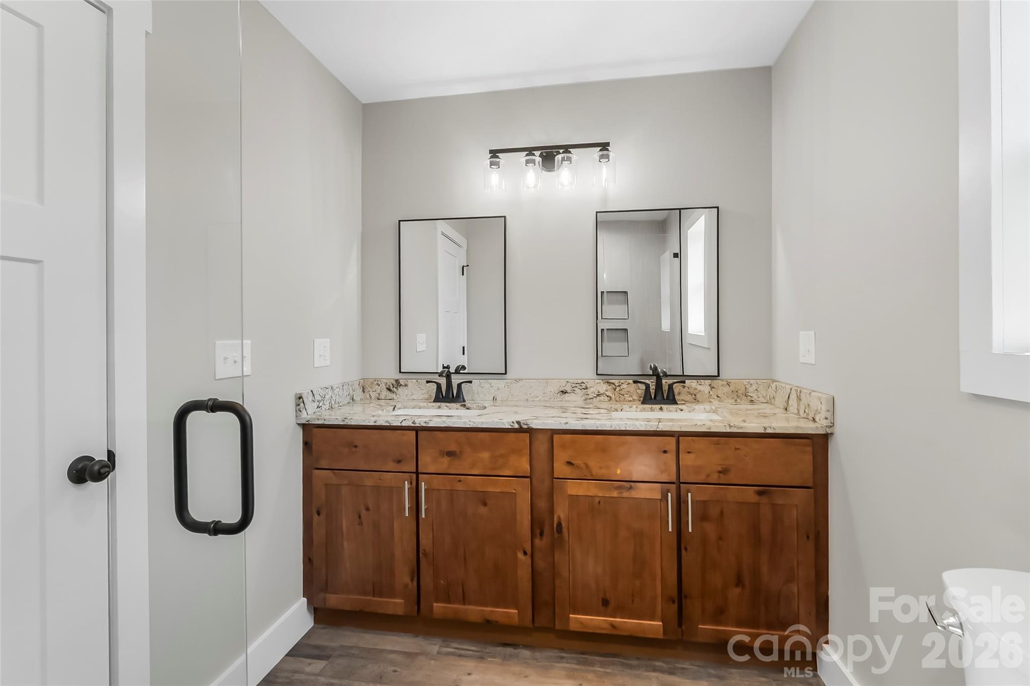 189 Clinchfield Gap Road Marion, NC 28752 - Photo 36 of 42 a bathroom with a granite countertop sink a toilet and a mirror