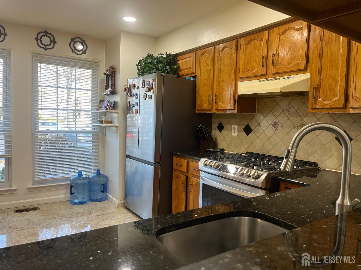 1505 Timber Oaks Road Edison, NJ 08820 - Photo 7 of 27 a kitchen with a refrigerator a stove a sink and a window