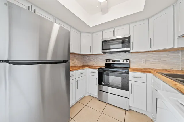 a kitchen with granite countertop white cabinets stainless steel appliances and a sink