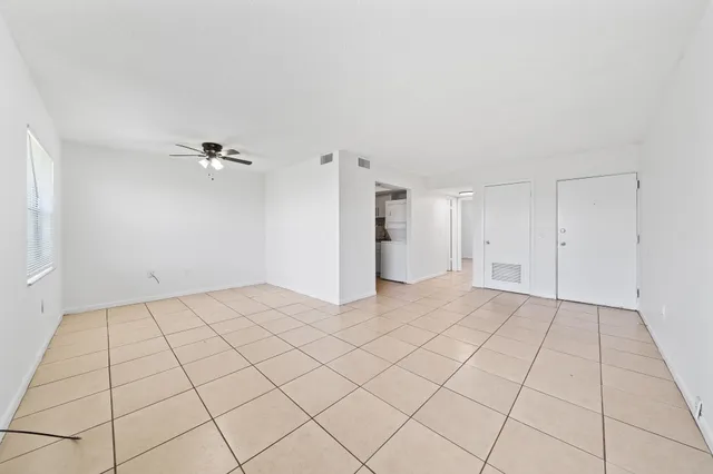 a view of an empty room with window and cabinet