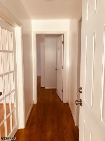 a view of a hallway with wooden floor and closet area