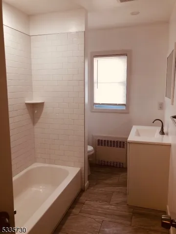 a bathroom with a tub a sink and a window