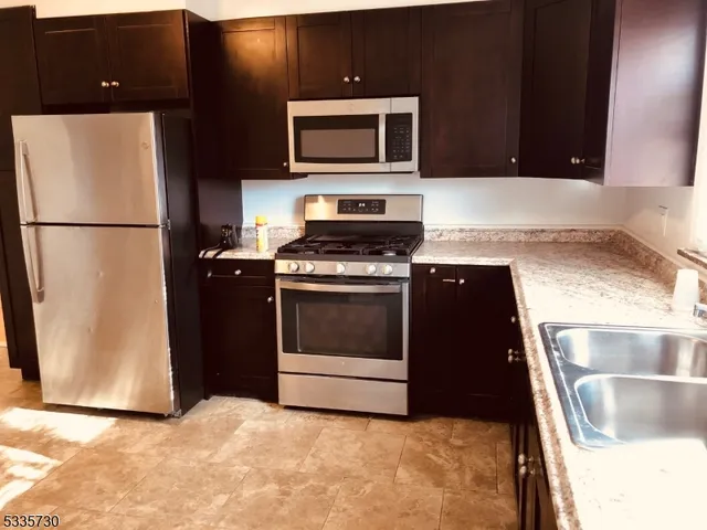 a kitchen with a stove top oven and refrigerator