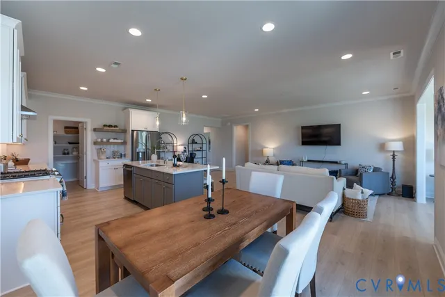 a living room with furniture a flat screen tv and kitchen view