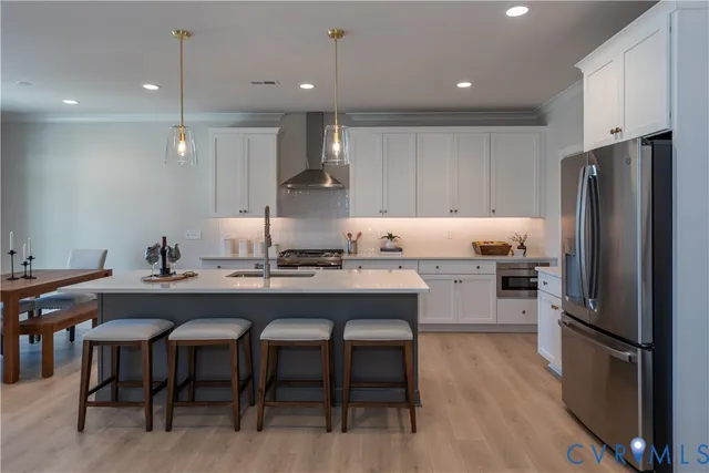a kitchen with stainless steel appliances granite countertop a sink refrigerator and cabinets