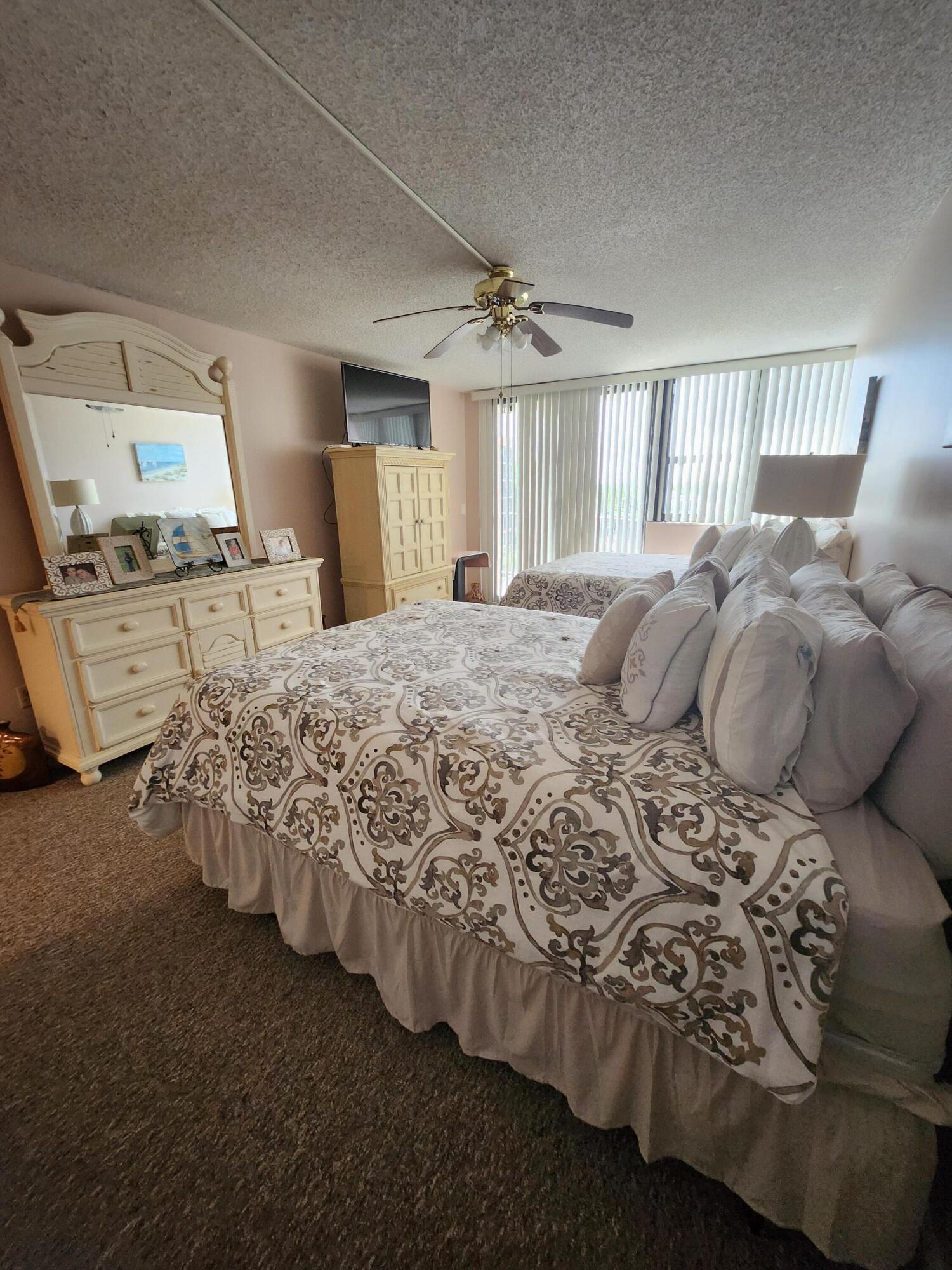 899 Jeffery Street, Unit 601 Boca Raton, FL 33487 - Photo 15 of 47 a bed sitting in a bedroom next to a window and a chandelier