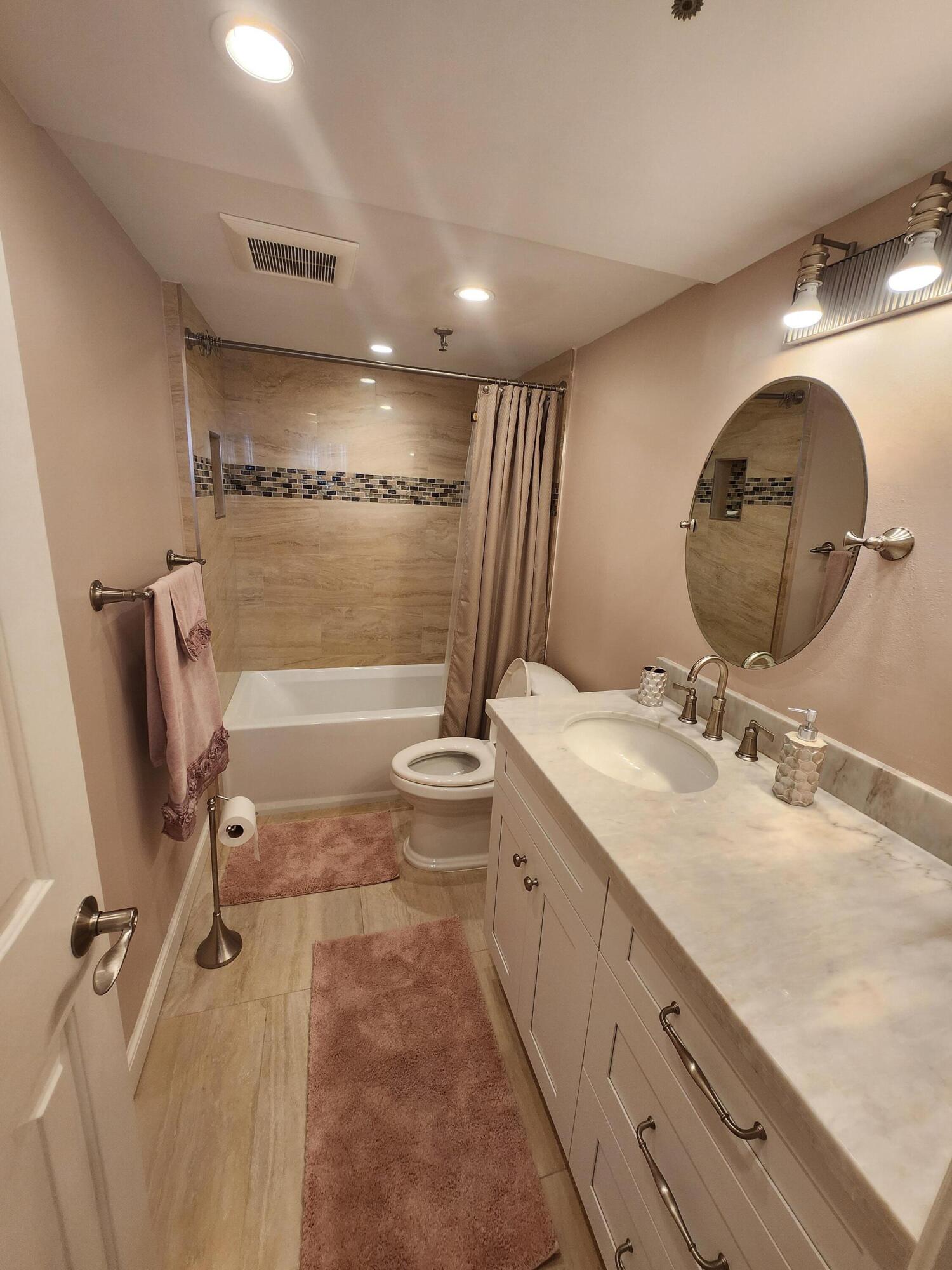 899 Jeffery Street, Unit 601 Boca Raton, FL 33487 - Photo 16 of 47 a bathroom with a double vanity sink and mirror with toilet
