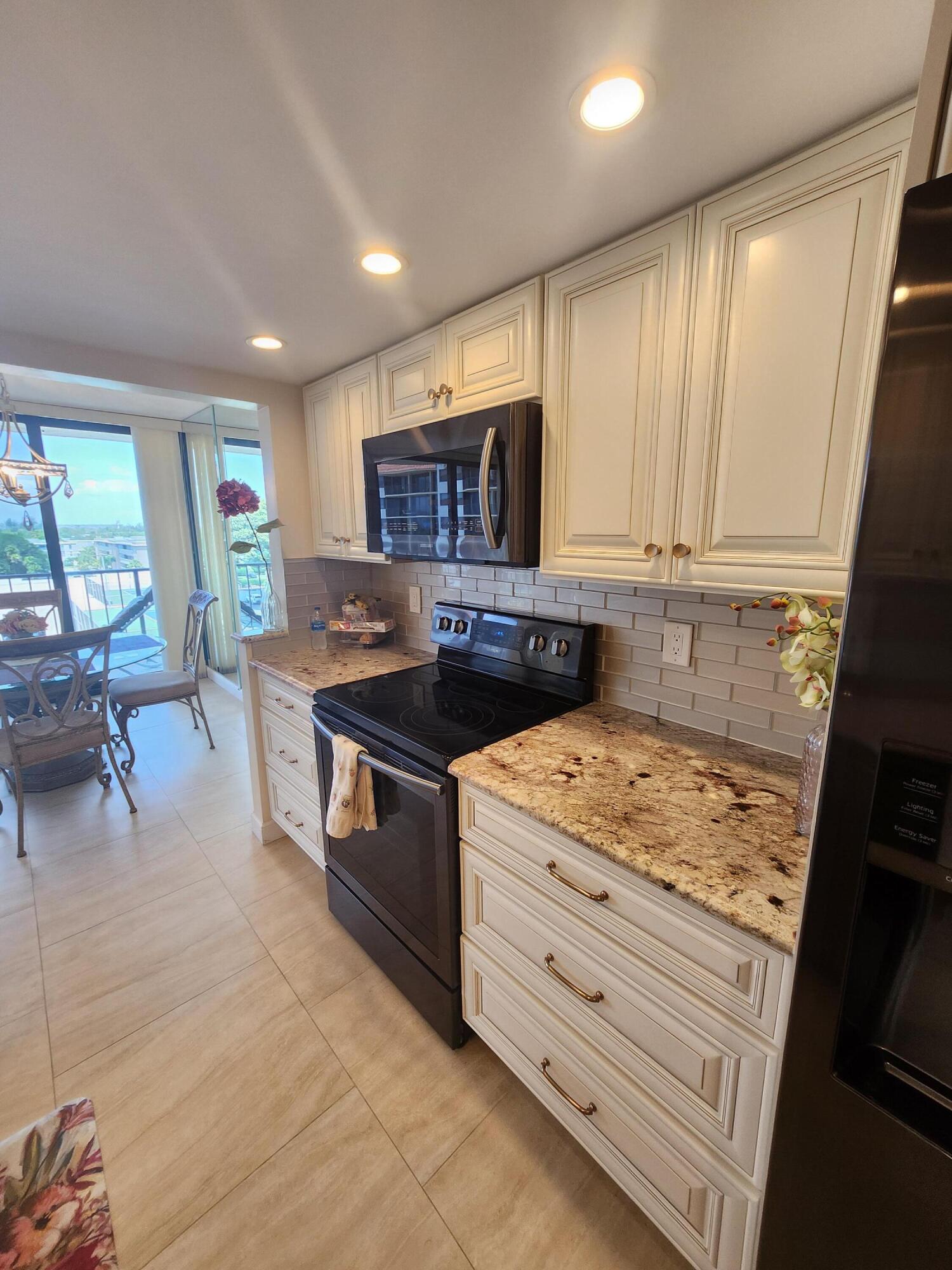 899 Jeffery Street, Unit 601 Boca Raton, FL 33487 - Photo 4 of 47 a kitchen with stainless steel appliances granite countertop a stove a sink and a microwave