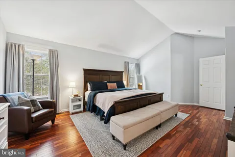 a bedroom with a bed couch and a large window