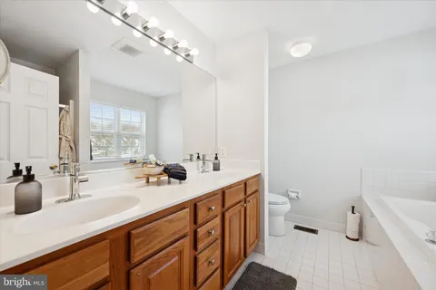 a bathroom with a sink a toilet a mirror and a bathtub