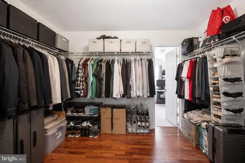 a view of walk in closet with clothes and shoes