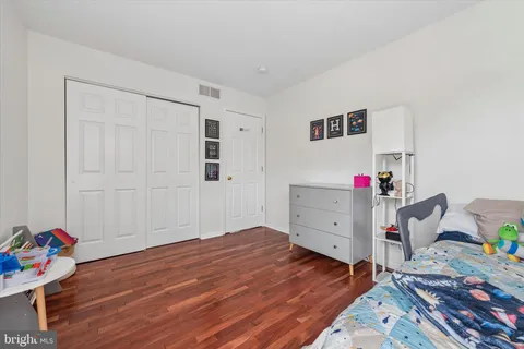 a bedroom with a bed and wooden floor