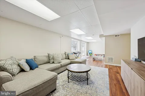 a living room with furniture a rug and a flat screen tv