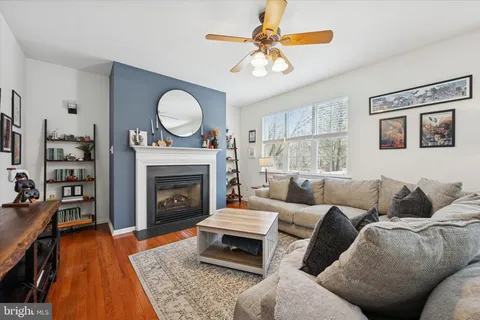 a living room with furniture a fireplace and a large window