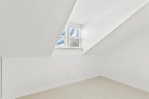 a view of a small space with wooden floor and a window