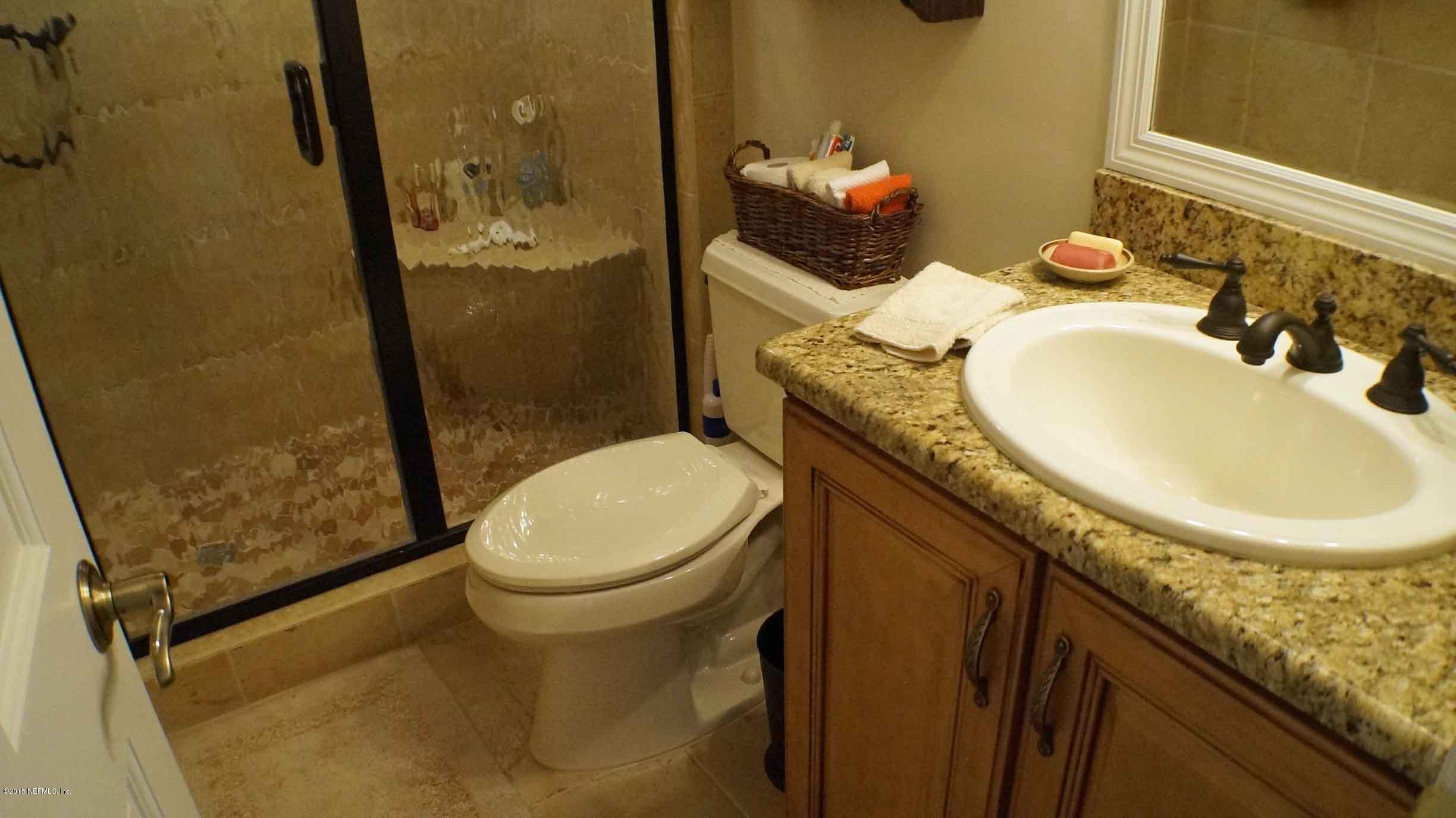 6674 Brooklyn Bay Road Keystone Heights, FL 32656 - Photo 26 of 57 a bathroom with a granite countertop toilet sink and mirror
