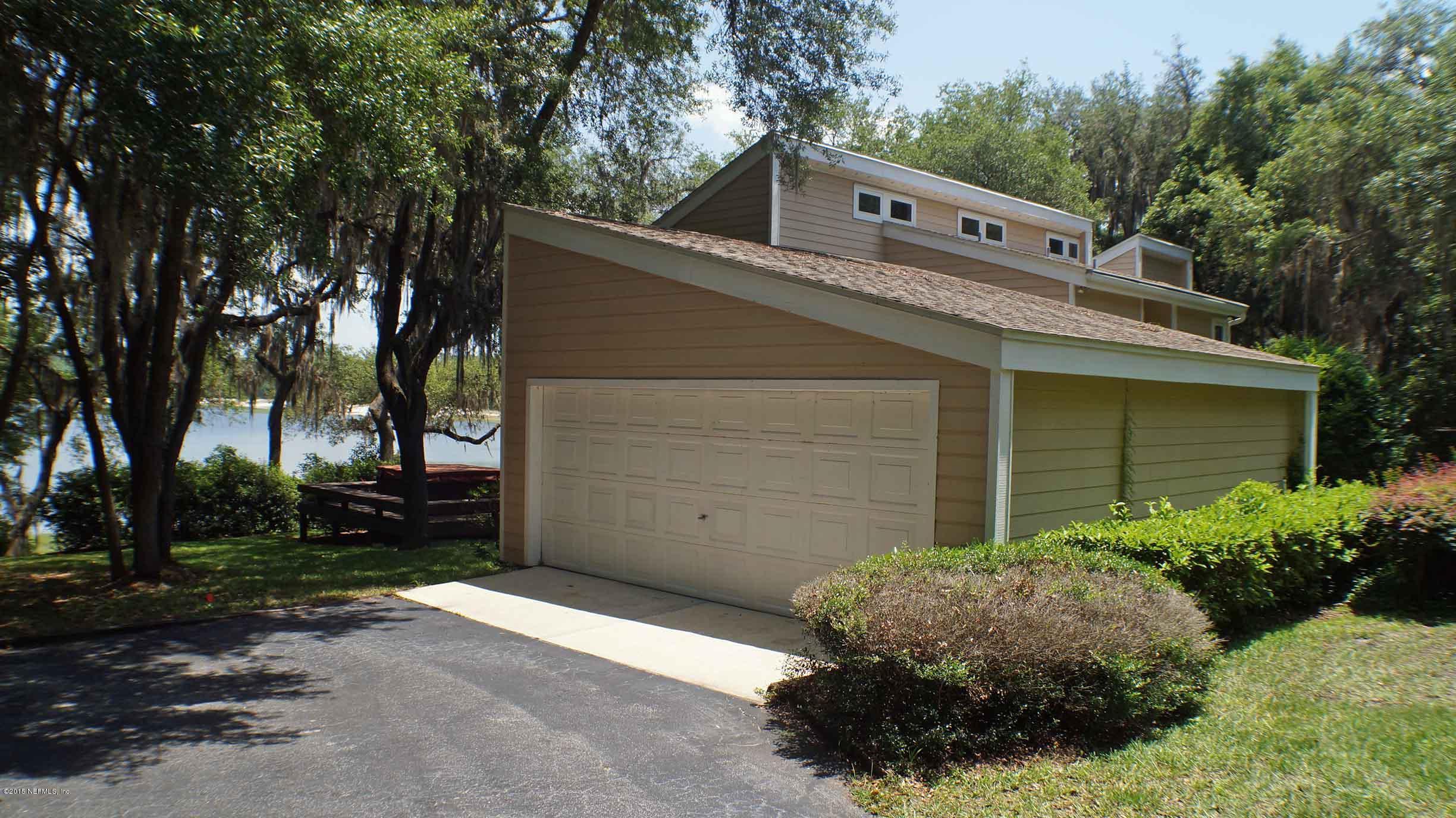 6674 Brooklyn Bay Road Keystone Heights, FL 32656 - Photo 53 of 57 a view of a house with a yard plants and large tree
