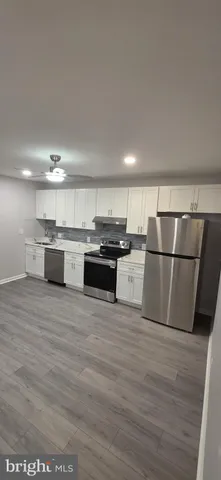 a kitchen with stainless steel appliances granite countertop a refrigerator oven a stove with wooden floors