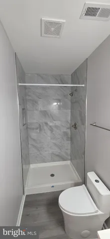 a bathroom with a toilet and a shower