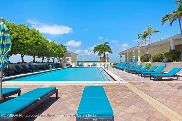 a view of an ocean with boats and trees in the background