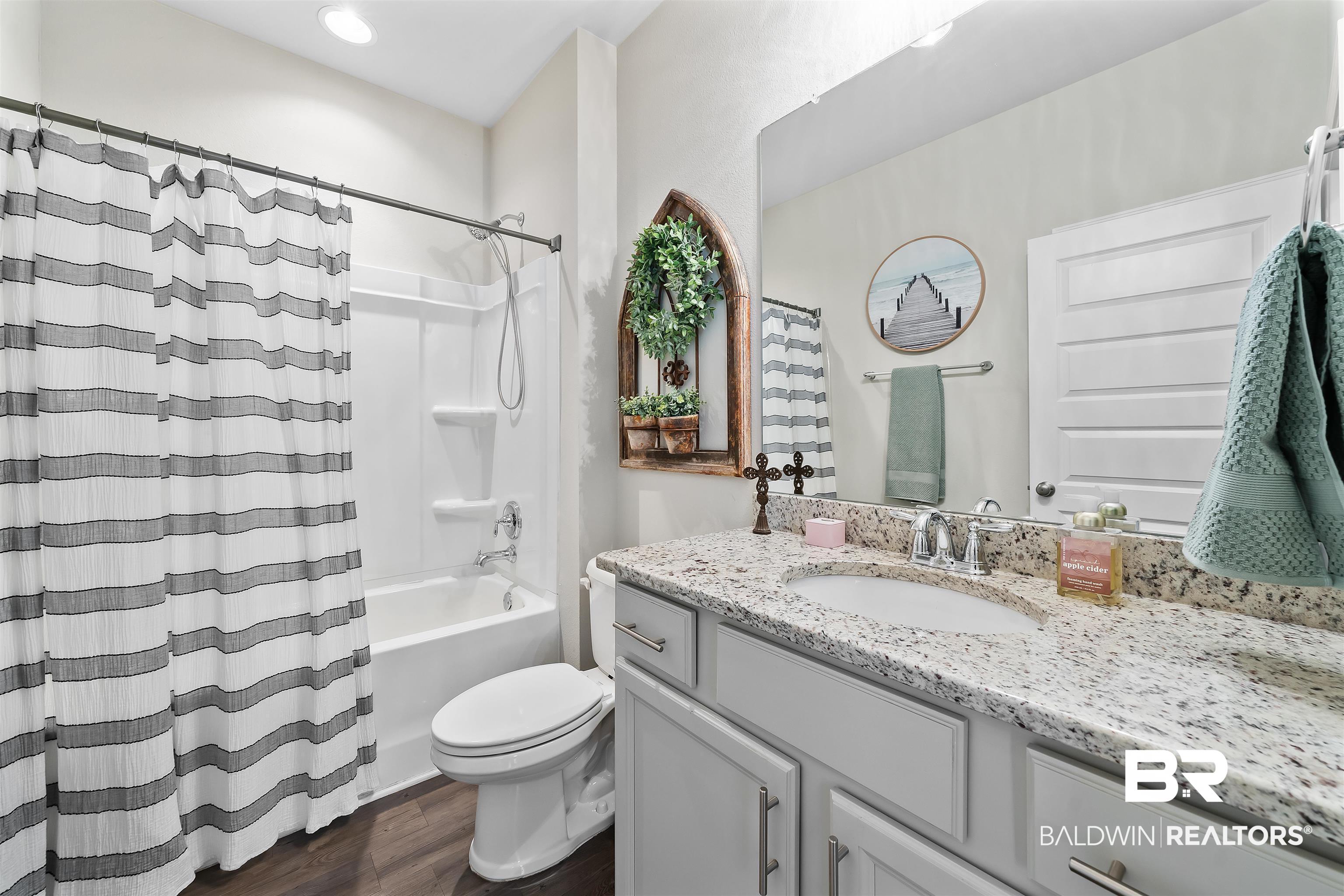 1221 Primrose Lane Foley, AL 36535 - Photo 8 of 29 Full bathroom featuring vanity, shower / bath combination with curtain, toilet, and wood finished floors