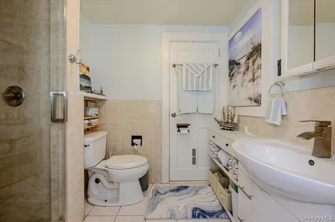 a bathroom with a sink toilet vanity and shower