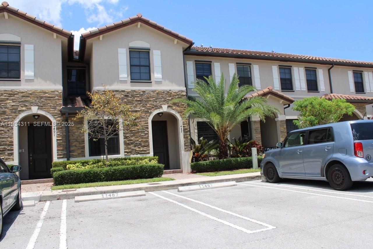 11487 Southwest 248th Lane Homestead, FL 33032 - Photo 2 of 16 a front view of a house with a yard and garage
