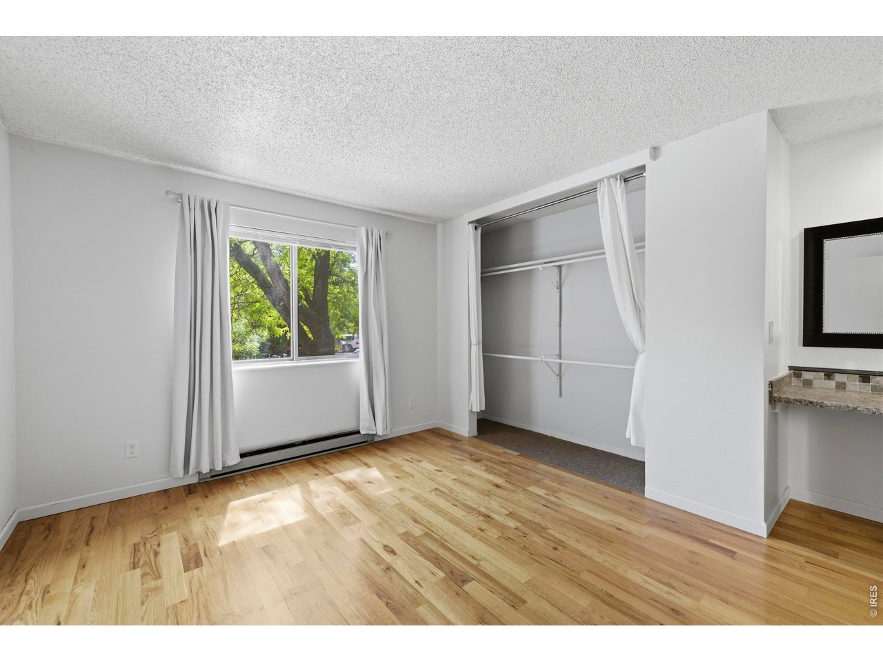 925 Columbia Road, Unit 824 Fort Collins, CO 80525 - Photo 13 of 36 a view of an empty room with a window and wooden floor