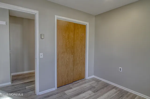 an empty room with wooden floor and closet