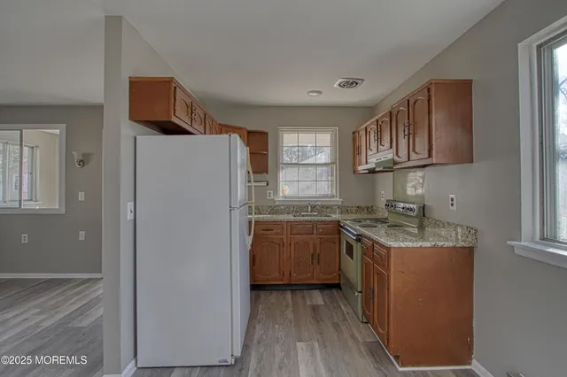 a kitchen with stainless steel appliances granite countertop a refrigerator sink and stove