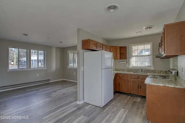 a kitchen with granite countertop a refrigerator stove top oven and sink