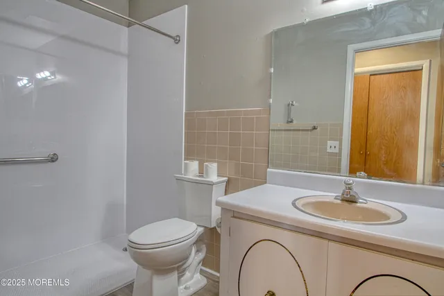 a bathroom with a sink a toilet and a mirror