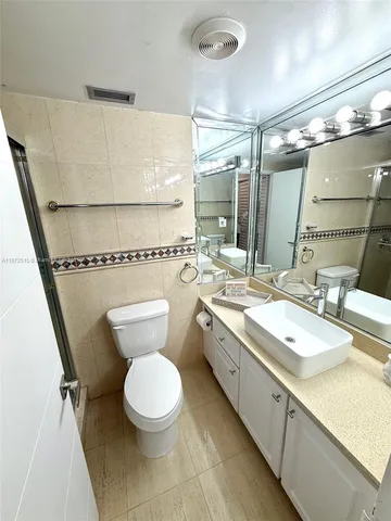 a bathroom with a double vanity sink mirror and toilet