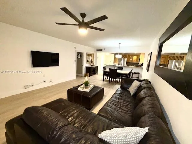 a living room with furniture and a flat screen tv with wooden floor