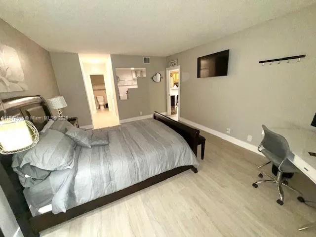 a bedroom with a bed and wooden floor