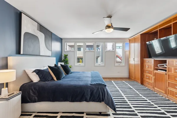 a bedroom with a large bed and a chandelier