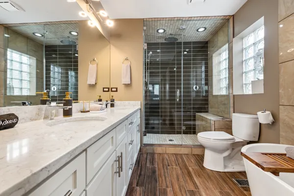 a bathroom with a double vanity sink toilet and shower