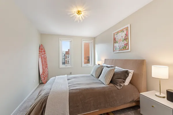 a bedroom with a bed and a painting on the wall