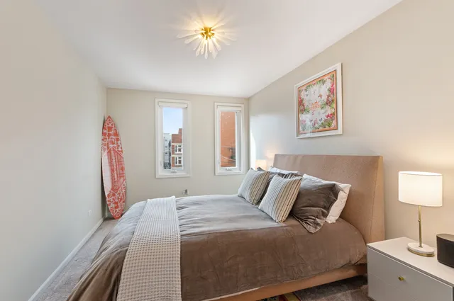 a bedroom with a bed and a painting on the wall