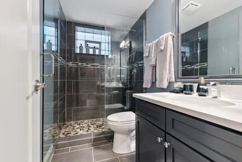 a bathroom with a sink a toilet and shower