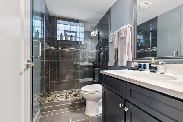 a bathroom with a sink a toilet and shower