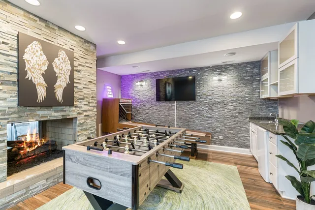 a kitchen with a stove a sink and a flat screen tv