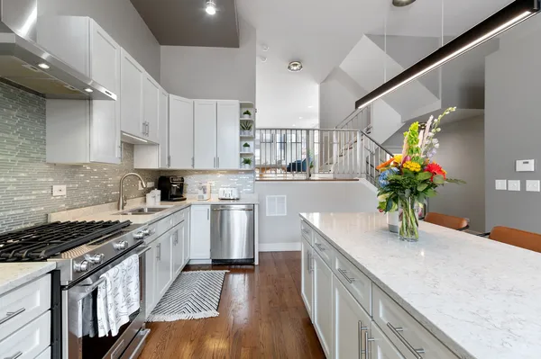 a kitchen with stainless steel appliances granite countertop a sink a stove top oven a counter space and cabinets