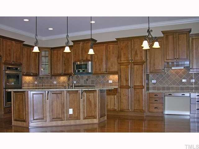 3903 Morvan Way Raleigh, NC 27612 - Photo 2 of 12 Gorgeous Tuscany inspired Chefs kitchen includes SS appls. double oven, gas cook top, juparana granite countertops, pantry & planning desk. Kitchen is open to the family room. To the left is access to screened porch. Kitchen