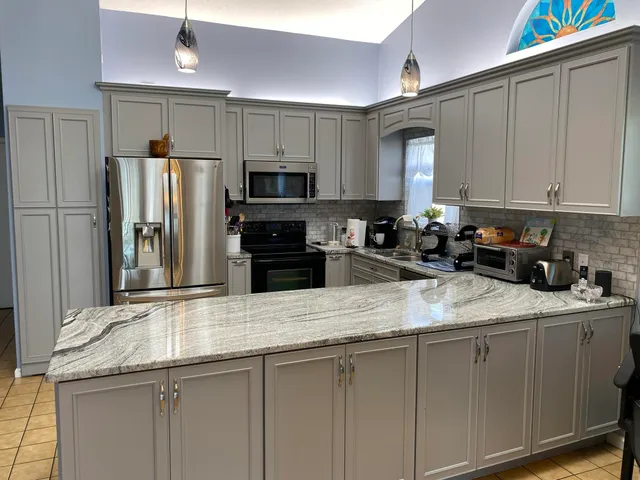 a kitchen with stainless steel appliances granite countertop a refrigerator sink and microwave