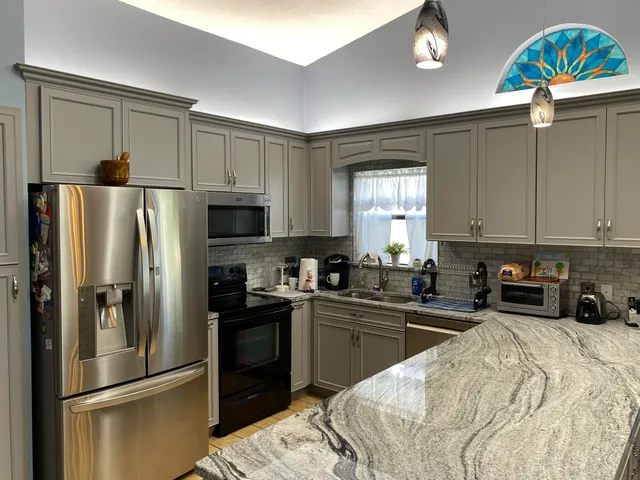 a kitchen with a sink stainless steel appliances and refrigerator