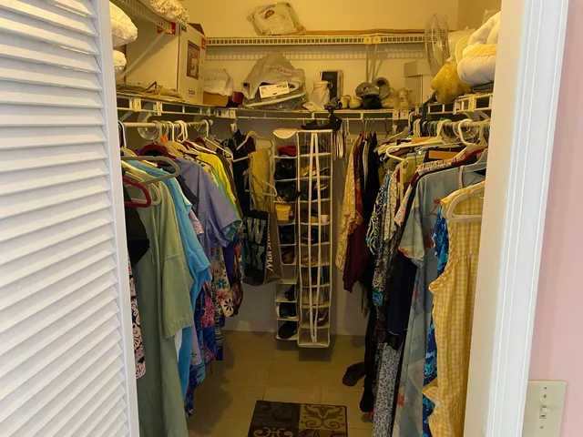 a large bed sitting in a bedroom next to a window with pc on the dresser