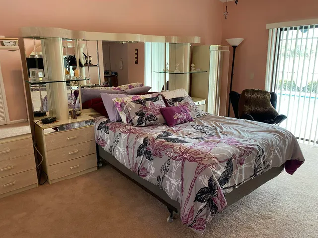 a bedroom with a bed and a flat tv screen on dresser