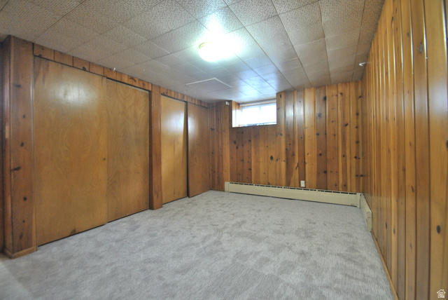 33 North 200 East Logan, UT 84321 - Photo 51 of 54 Below grade area featuring light carpet, wood walls, and a baseboard heating unit